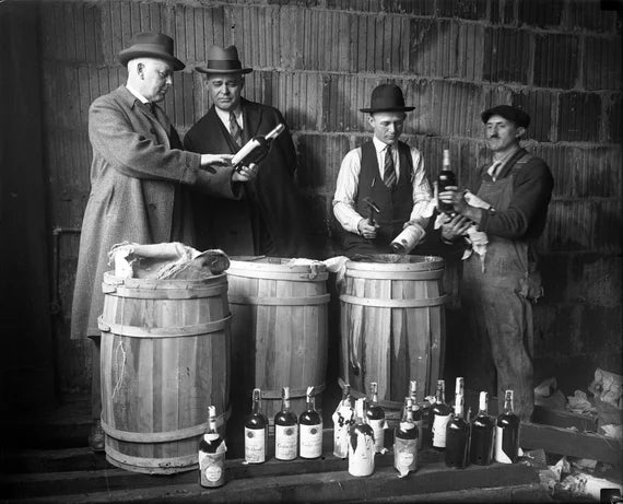 Prohibition-era agents inspecting confiscated liquor with barrels