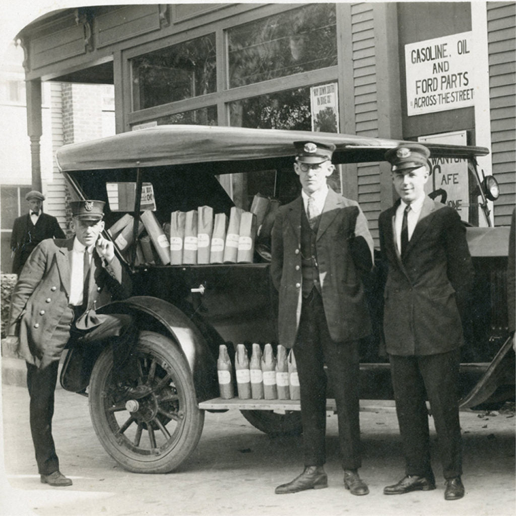 Prohibition-era delivery crew with a Ford truck loaded with wrapped bottles